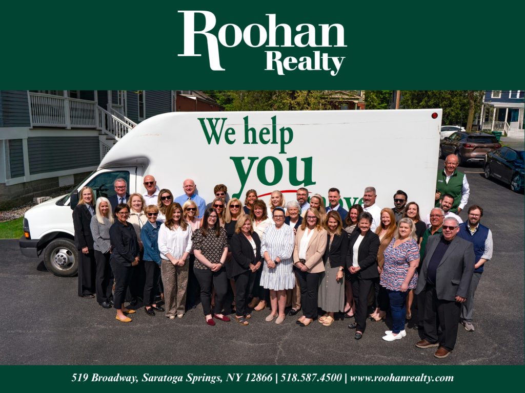 Roohan Realty staff and agents standing in-front of their complementary moving truck.